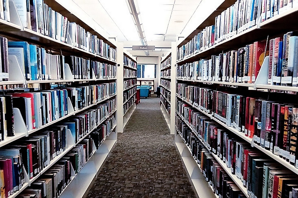 Blick in entlang der Bücherregale einer modernen Bibliothek