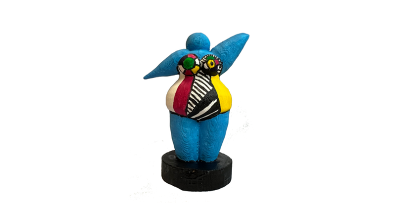Bunte Nana-Figur mit ausgestreckten Armen und abstraktem Muster in Blau, Rot, Gelb, Schwarz und Weiß auf schwarzem Sockel.