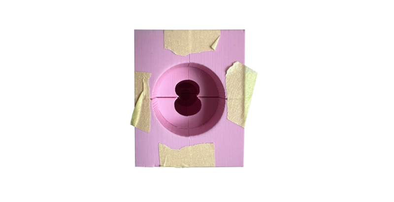 Aus vier Teilen zusammengesetzte rosa Silikonform, mit Klebeband fixiert und mit runder Öffnung für den Gussprozess.