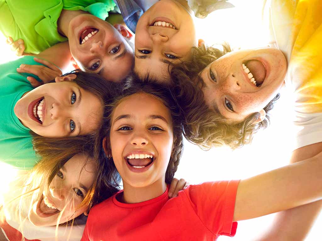 Das Bild zeigt das Reichstagsgebäude in Berlin, Deutschland. Im Vordergrund weht die deutsche Flagge. Auf dem Gebäude ist die Inschrift DEM DEUTSCHEN VOLKE zu sehen. Im Hintergrund ist die markante gläserne Kuppel des Reichstags zu erkennen. Der Himmel ist klar und blau