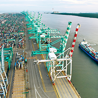 Containerhafen  - Ein Schiff fährt an Kränen vorbei