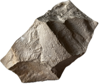 Das Bild zeigt einen ungleichmäßig geformten grauen Stein mit scharfen Kanten