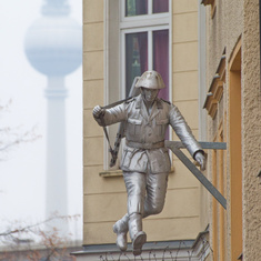 Symbolbild für den Bau der Mauer: ein Soldat, der über Stacheldraht springt
